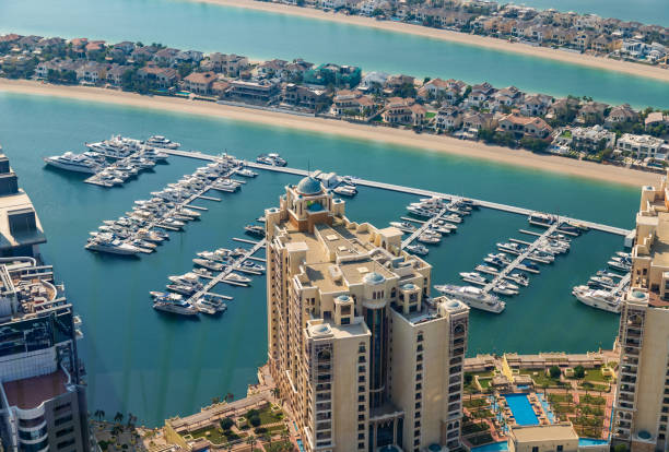 Aerial view of luxury yachts docked at a marina near high-end residential areas in Dubai.